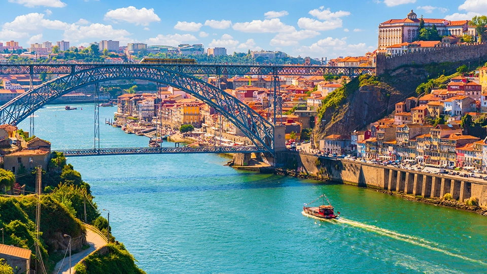 Picturesque, colorful view at old town Porto, Portugal with bridge Ponte Dom Luis over Douro river. Oporto, touristic mediterranean city of culture, architecture, wine, sport and gastronomy.